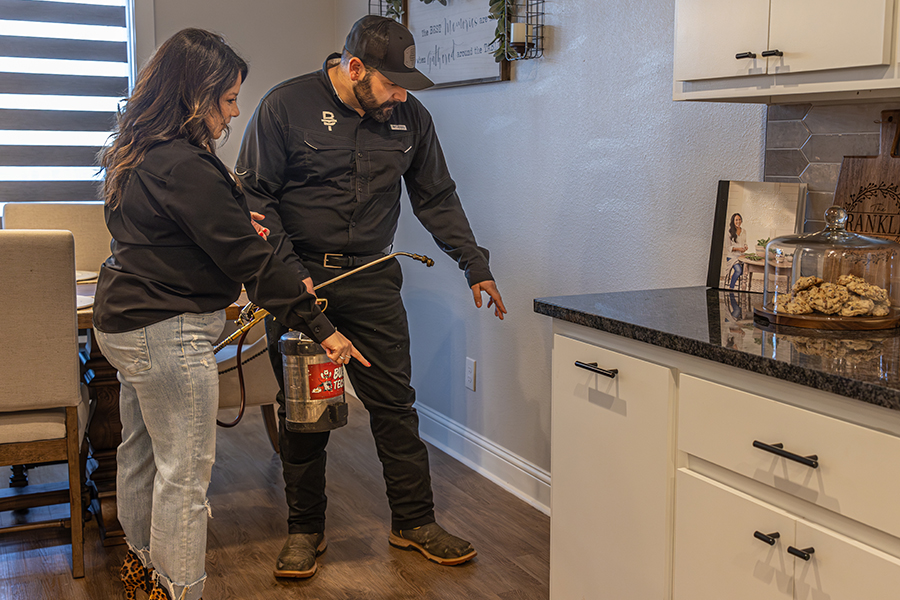 Bug Tech Pest Control technician with a homeowner discussing termite treatment in her dining room.